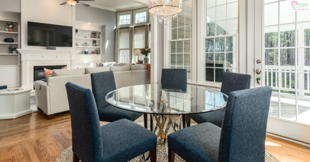 A dining room table with blue chairs and a chandelier.